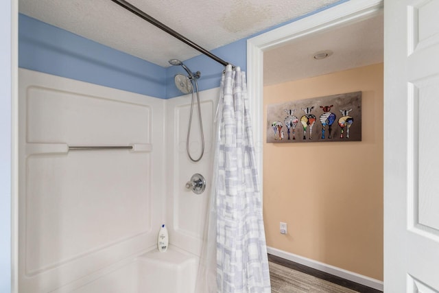 bathroom featuring a textured ceiling, a shower with curtain, and hardwood / wood-style flooring