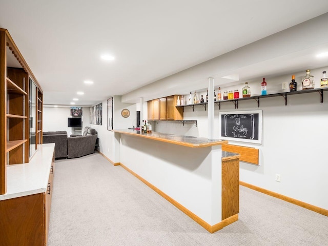 kitchen featuring a kitchen breakfast bar, kitchen peninsula, and light carpet