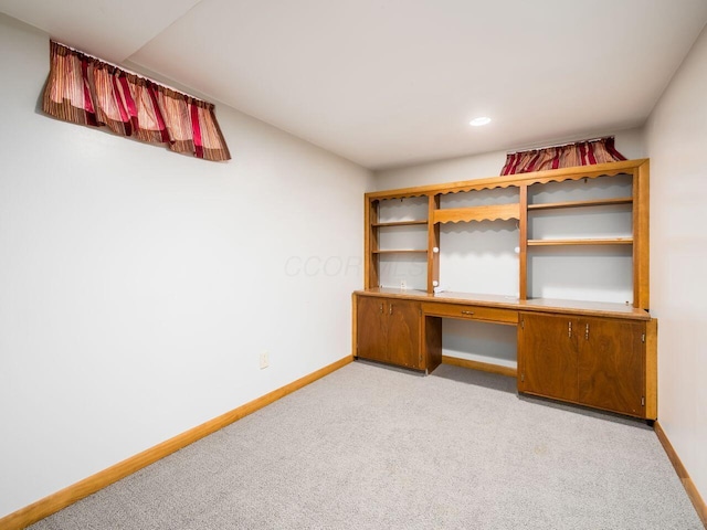 unfurnished office with built in desk and light colored carpet