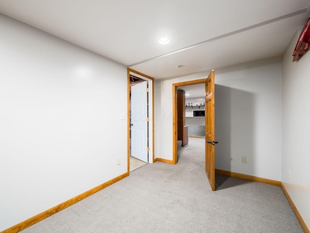 unfurnished room featuring light carpet