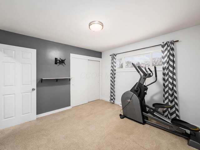 workout room featuring light carpet