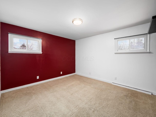 empty room featuring a baseboard radiator and carpet