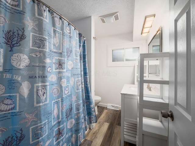 bathroom featuring hardwood / wood-style flooring, vanity, toilet, a textured ceiling, and a shower with curtain