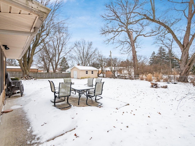 yard layered in snow featuring an outdoor structure