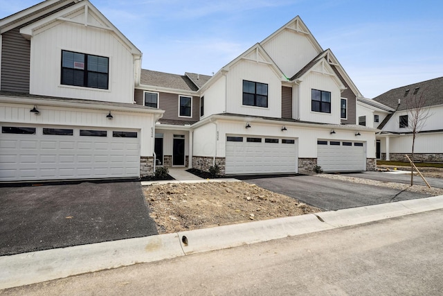 view of front of home with stone siding, driveway, and an attached garage