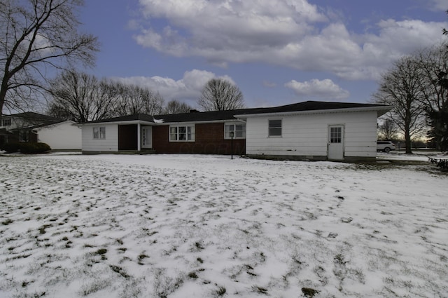 view of snow covered back of property