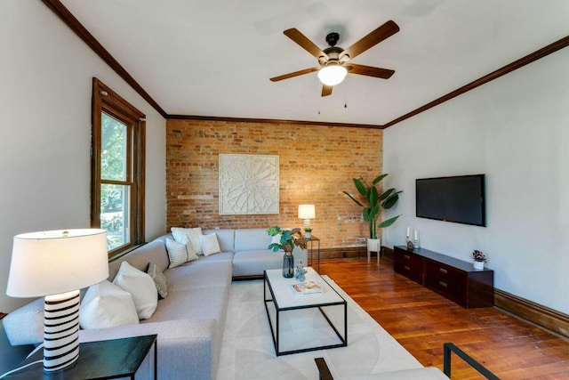 living room with ceiling fan, brick wall, crown molding, and wood-type flooring