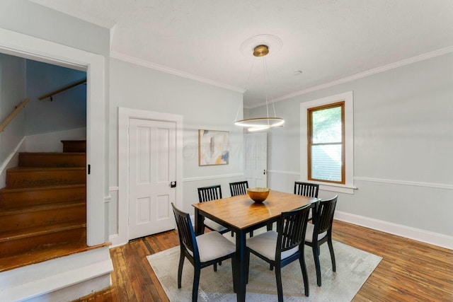 dining area with dark hardwood / wood-style flooring and crown molding