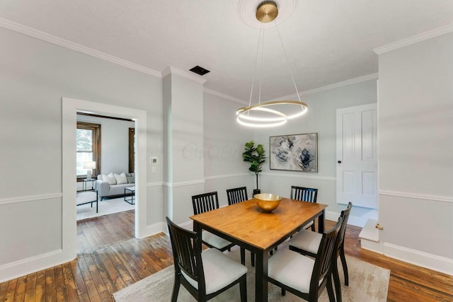 dining space with dark hardwood / wood-style flooring and ornamental molding