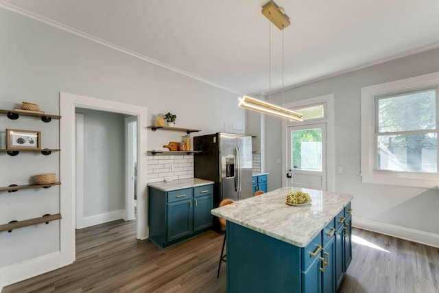 kitchen featuring a kitchen island, pendant lighting, a kitchen bar, and blue cabinetry