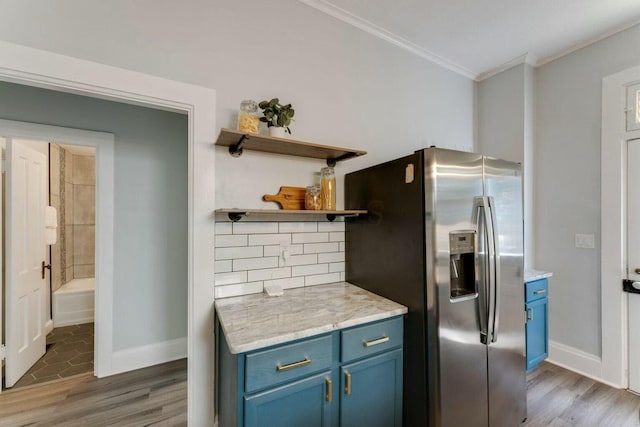 kitchen with tasteful backsplash, stainless steel fridge with ice dispenser, blue cabinetry, and ornamental molding