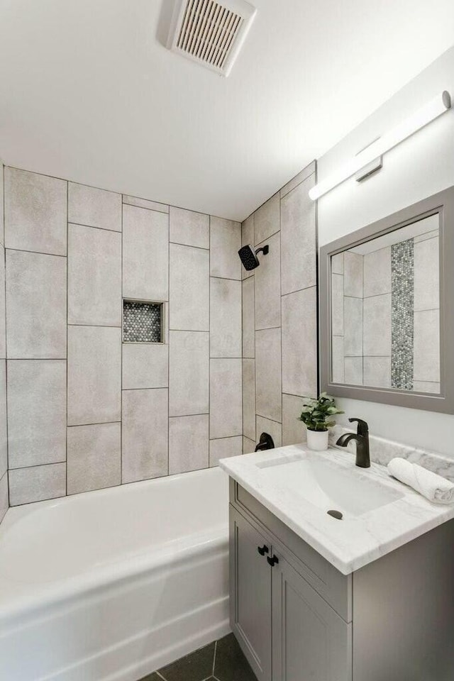 bathroom featuring vanity, tiled shower / bath combo, and tile patterned floors