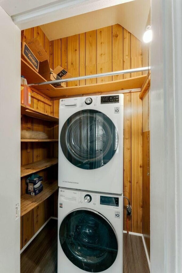 laundry room with stacked washer / dryer and dark hardwood / wood-style floors