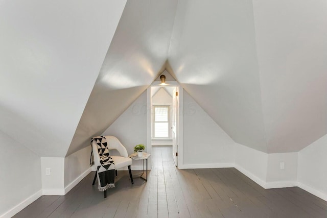 bonus room with dark wood-type flooring and lofted ceiling