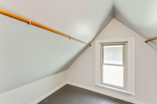 bonus room with dark hardwood / wood-style floors and vaulted ceiling