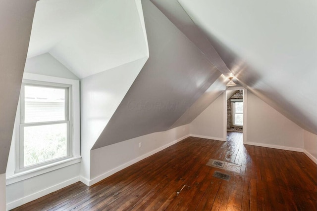 additional living space with vaulted ceiling and dark hardwood / wood-style flooring