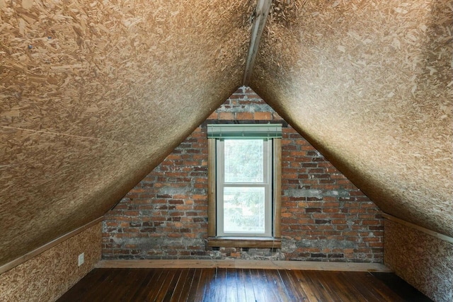 additional living space with hardwood / wood-style flooring and lofted ceiling