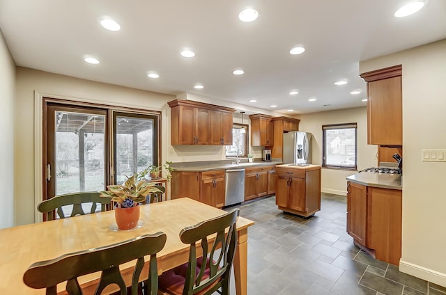 kitchen featuring appliances with stainless steel finishes, sink, a kitchen island, and a wealth of natural light