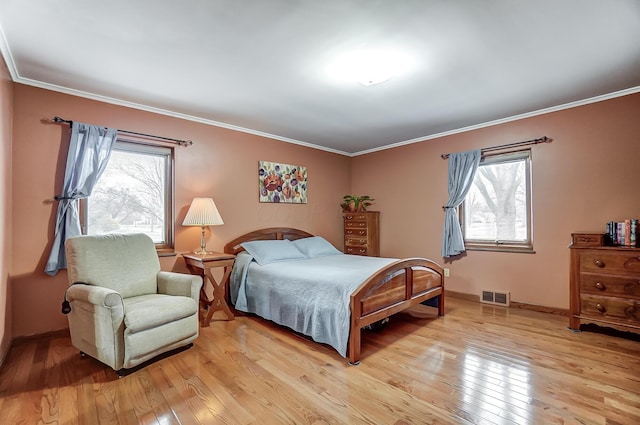 bedroom featuring crown molding and light wood-type flooring