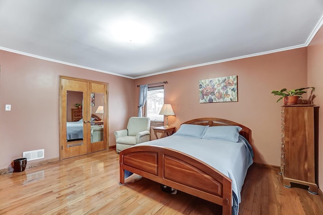 bedroom with crown molding and light hardwood / wood-style flooring