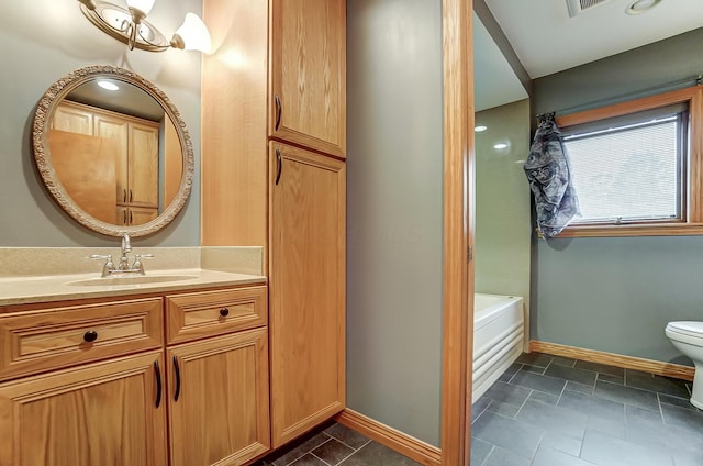 bathroom featuring vanity, a bath, and toilet