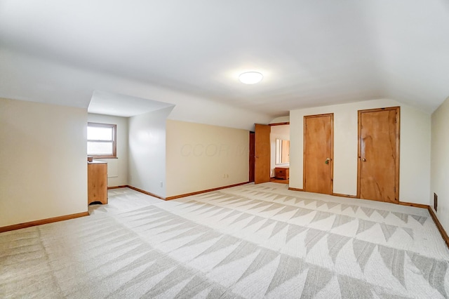 bonus room featuring vaulted ceiling and light carpet