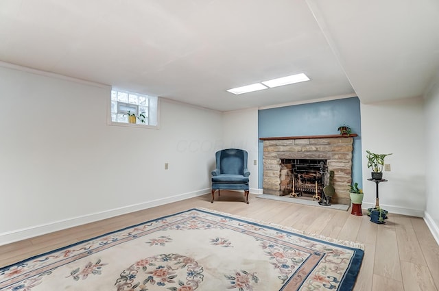 living area featuring a stone fireplace and light hardwood / wood-style floors