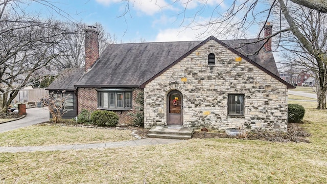 tudor home with a front lawn