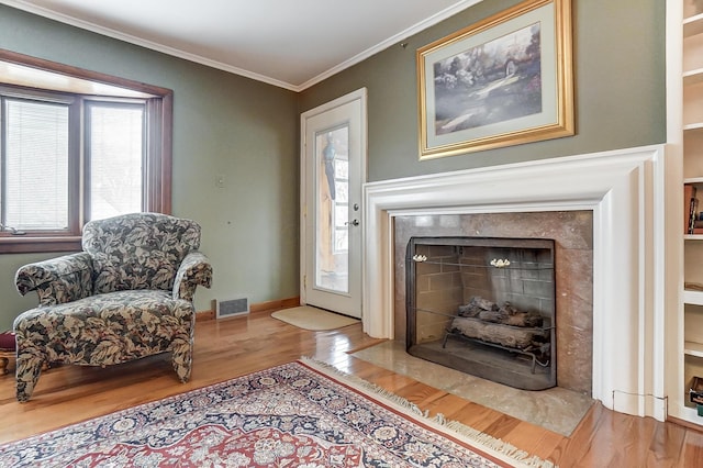 living area with ornamental molding and light wood-type flooring