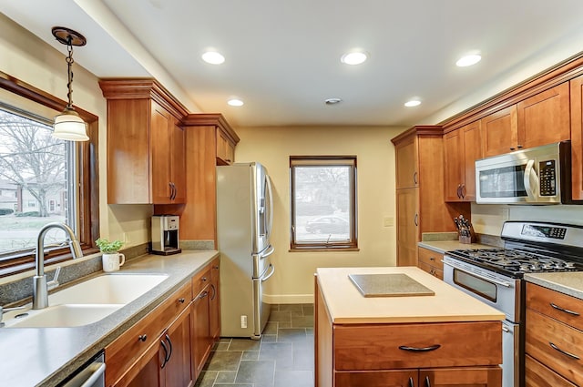 kitchen featuring pendant lighting, stainless steel appliances, sink, and a wealth of natural light