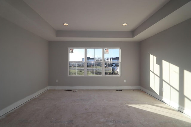 unfurnished room featuring a raised ceiling