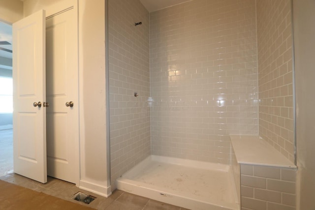 bathroom with tile patterned floors and a tile shower