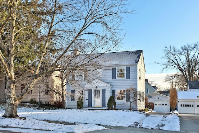 colonial-style house featuring a garage and an outdoor structure