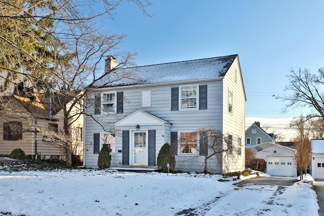 colonial home with a garage and an outbuilding