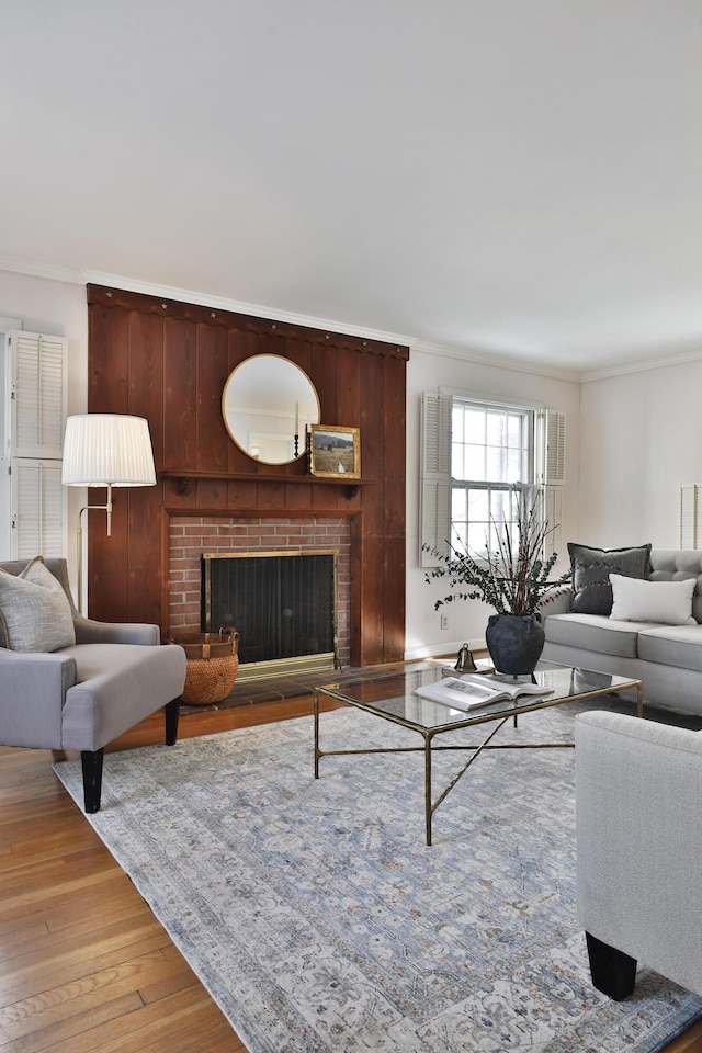 living room featuring light hardwood / wood-style floors, ornamental molding, and a fireplace