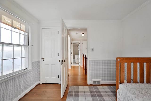 bedroom featuring crown molding and light hardwood / wood-style floors