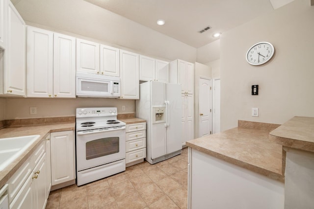 kitchen with light tile patterned flooring, white cabinetry, and white appliances