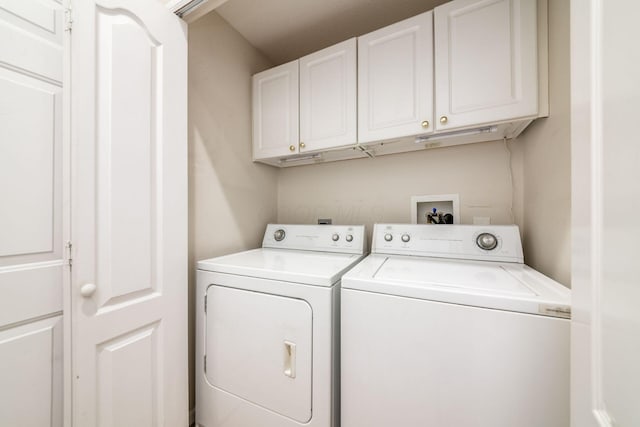 washroom featuring independent washer and dryer and cabinets