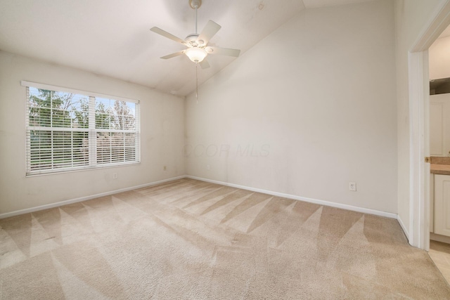 carpeted empty room featuring ceiling fan and vaulted ceiling