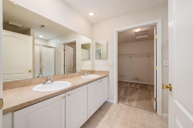 bathroom featuring a shower with shower door and vanity