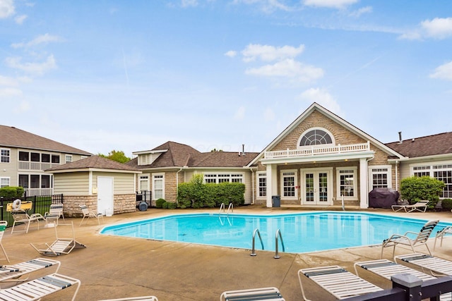 view of pool with area for grilling, french doors, and a patio