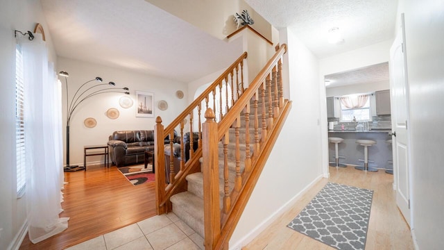 stairway featuring hardwood / wood-style flooring and a textured ceiling