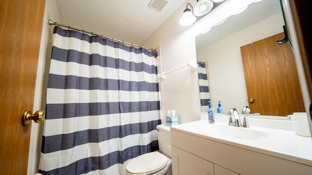 bathroom with vanity, a shower with curtain, toilet, and a textured ceiling