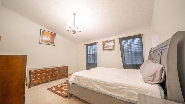 carpeted bedroom featuring an inviting chandelier, vaulted ceiling, and a textured ceiling