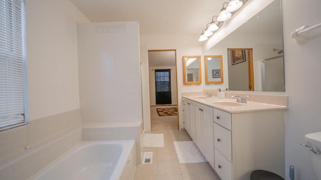 bathroom featuring tile patterned flooring, vanity, plus walk in shower, and a textured ceiling