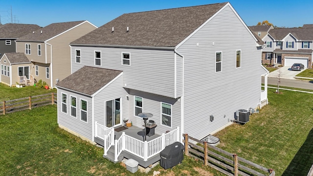 back of property with a deck, central air condition unit, and a lawn