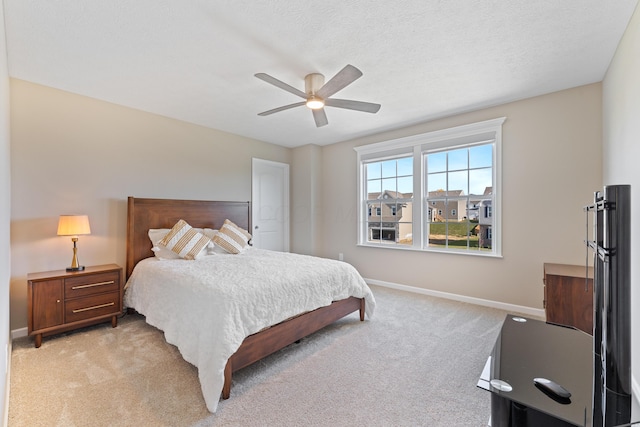 carpeted bedroom featuring a textured ceiling and ceiling fan