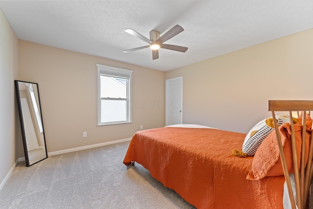 bedroom featuring light carpet, ceiling fan, and a textured ceiling