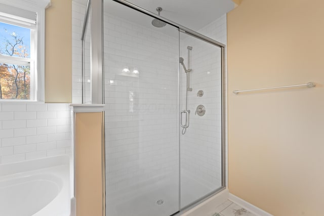 bathroom featuring shower with separate bathtub