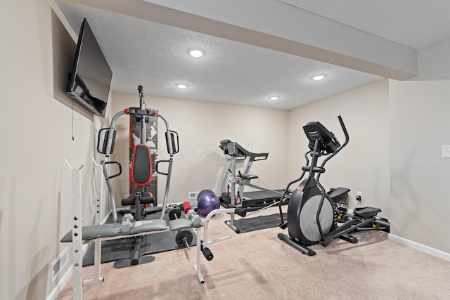 workout area featuring a textured ceiling and carpet floors